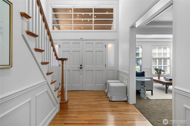 2020 Evergreen Point Rd, Medina, WA 98039 - entryway with light wood-type flooring, stairs, wainscoting, and a decorative wall