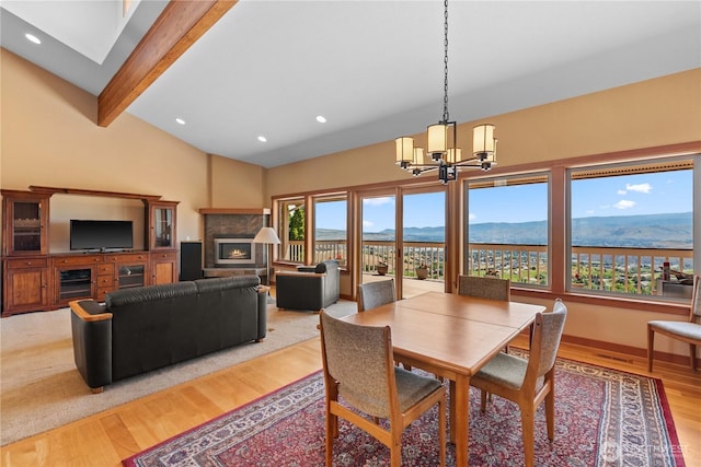 4261 April Dr, Wenatchee, WA 98801 - dining area with beam ceiling, light wood-style flooring, a chandelier, a warm lit fireplace, and recessed lighting