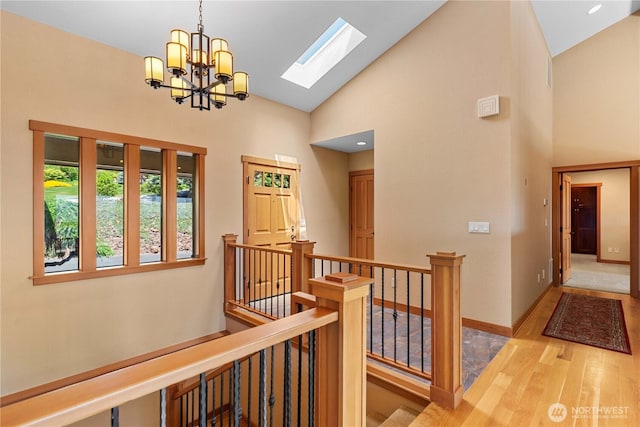4261 April Dr, Wenatchee, WA 98801 - hallway with wood finished floors, high vaulted ceiling, an upstairs landing, a skylight, and a chandelier