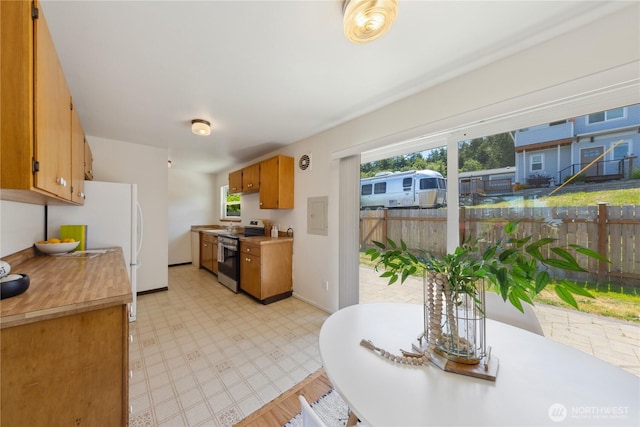 3309 W 2nd St, Anacortes, WA 98221 - kitchen featuring stainless steel electric stove, light floors, light countertops, and brown cabinets