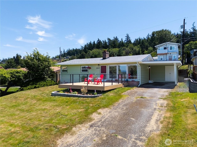 3309 W 2nd St, Anacortes, WA 98221 - view of front of home featuring driveway, a wooden deck, a front yard, a chimney, and an attached carport