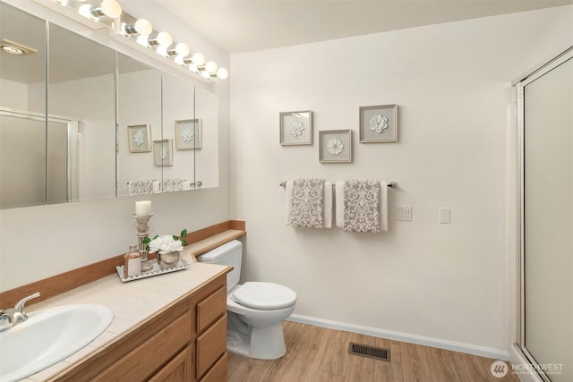 3673 224th Pl SE Unit 1349, Issaquah, WA 98029 - full bathroom with toilet, vanity, a shower with shower door, wood finished floors, and baseboards