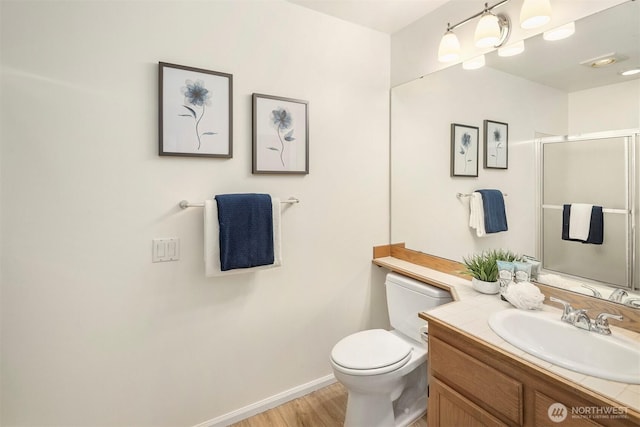 3673 224th Pl SE Unit 1349, Issaquah, WA 98029 - bathroom featuring toilet, vanity, wood finished floors, baseboards, and an enclosed shower