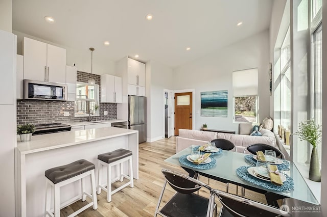 1808 S Raymond St, Seattle, WA 98108 - kitchen with appliances with stainless steel finishes, a sink, tasteful backsplash, light countertops, and white cabinets