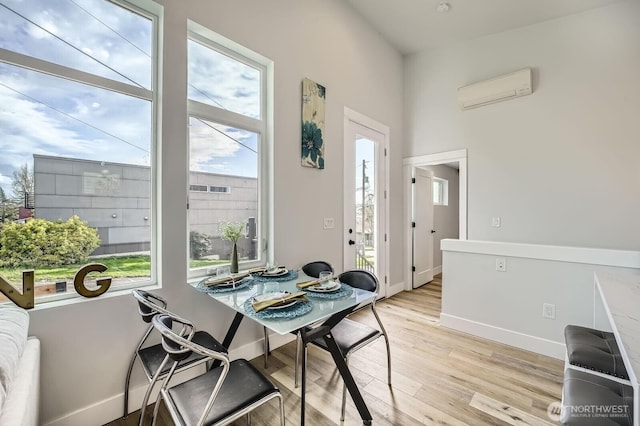 1808 S Raymond St, Seattle, WA 98108 - dining room featuring a wall unit AC, light wood-style flooring, and baseboards