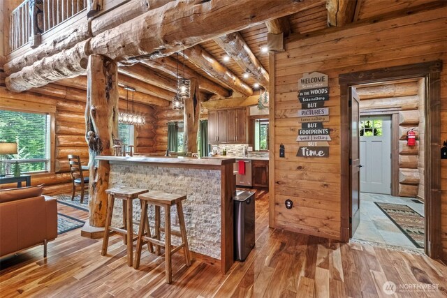 158 Big Pine Dr, Leavenworth, WA 98826 - kitchen with light wood-style flooring, a kitchen bar, healthy amount of natural light, rustic walls, and beamed ceiling