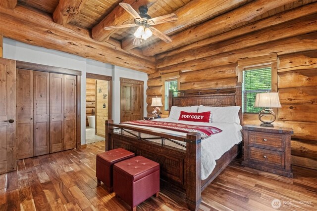 158 Big Pine Dr, Leavenworth, WA 98826 - bedroom featuring wood ceiling with exposed beams, hardwood / wood-style floors, log walls, two closets, and ensuite bathroom
