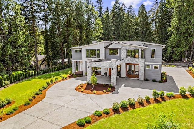 23036 35th Ave SE, Bothell, WA 98021 - modern home featuring stone siding, driveway, a carport, a front yard, and a patio area