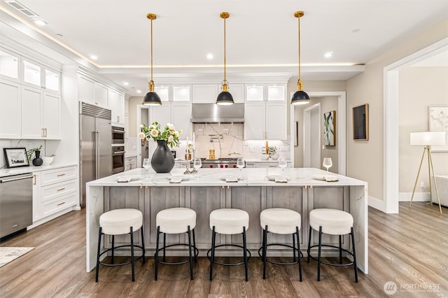 23036 35th Ave SE, Bothell, WA 98021 - kitchen featuring appliances with stainless steel finishes, tasteful backsplash, exhaust hood, white cabinets, and recessed lighting