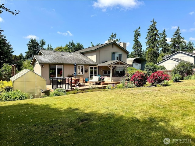 1711 Mount Rainier Blvd, Spanaway, WA 98387 - back of property with a chimney, a yard, an outdoor structure, and a carport