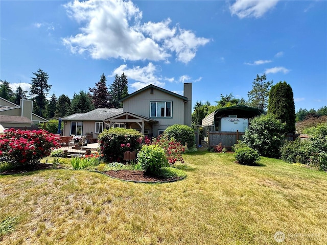 1711 Mount Rainier Blvd, Spanaway, WA 98387 - back of house featuring a patio, a detached carport, and a chimney