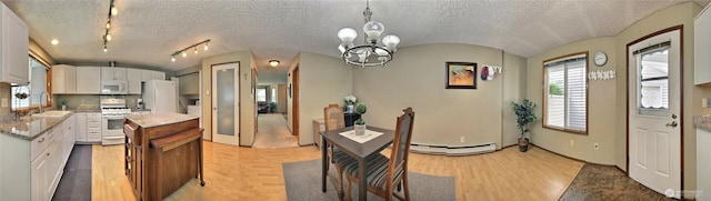 152 S 324th Pl Unit 65, Federal Way, WA 98003 - kitchen with white appliances, a sink, white cabinets, a kitchen island, and a textured ceiling
