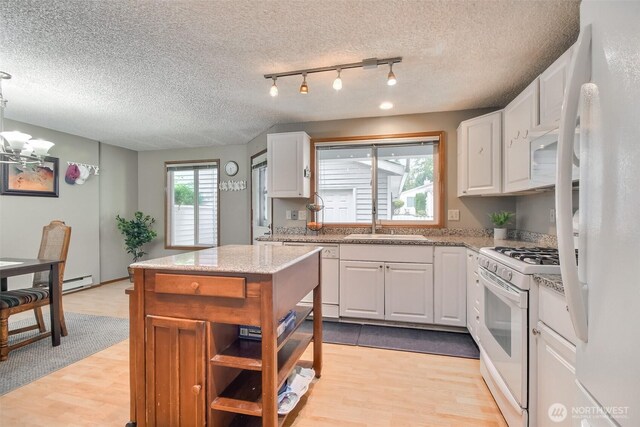 152 S 324th Pl Unit 65, Federal Way, WA 98003 - kitchen with white appliances, light wood-type flooring, white cabinets, a textured ceiling, and a chandelier