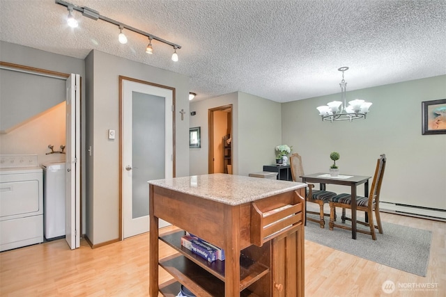 152 S 324th Pl Unit 65, Federal Way, WA 98003 - kitchen with light wood-type flooring, a textured ceiling, washer and dryer, a chandelier, and a kitchen island