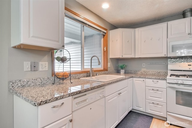 152 S 324th Pl Unit 65, Federal Way, WA 98003 - kitchen with white appliances, a sink, white cabinetry, and light stone countertops