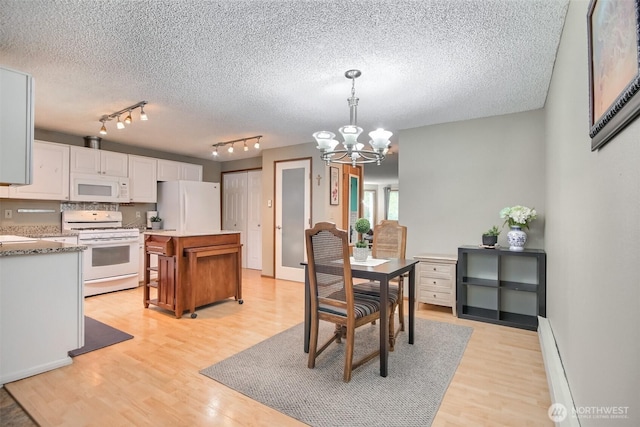 152 S 324th Pl Unit 65, Federal Way, WA 98003 - dining space featuring a chandelier, light wood-style floors, a textured ceiling, and rail lighting