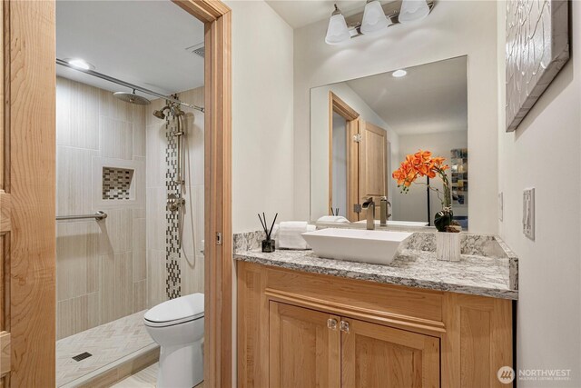 215 9th St Unit D101, Kirkland, WA 98033 - bathroom featuring vanity, toilet, and tiled shower