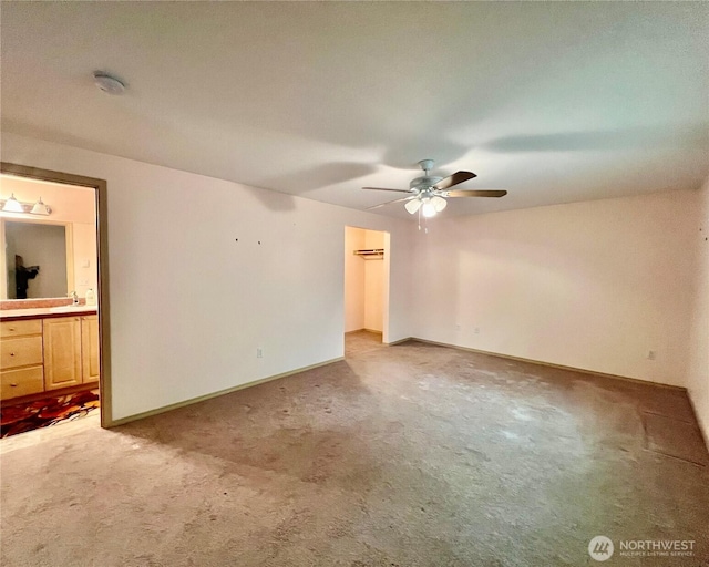 30211 O Pl, Ocean Park, WA 98640 - unfurnished bedroom with light carpet, baseboards, ensuite bath, a walk in closet, and a ceiling fan
