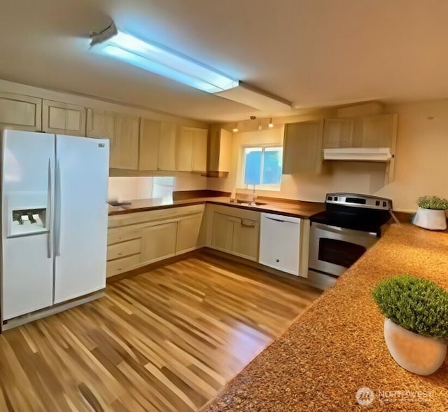 30211 O Pl, Ocean Park, WA 98640 - kitchen featuring white appliances, under cabinet range hood, light wood finished floors, dark countertops, and a sink