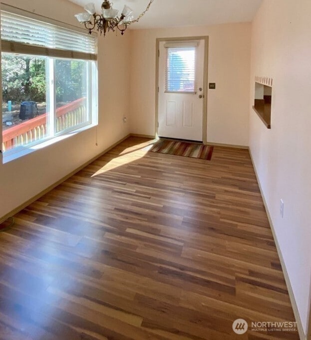 30211 O Pl, Ocean Park, WA 98640 - unfurnished dining area with a chandelier, wood finished floors, and baseboards