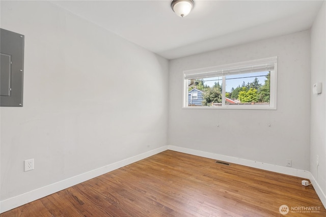17004 11th Ave NE, Shoreline, WA 98155 - empty room with electric panel, baseboards, and wood finished floors