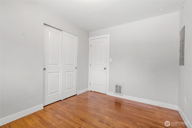 17004 11th Ave NE, Shoreline, WA 98155 - unfurnished bedroom featuring baseboards, wood finished floors, and a closet