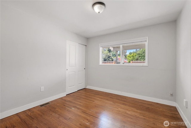 17004 11th Ave NE, Shoreline, WA 98155 - unfurnished bedroom with baseboards, wood finished floors, and a closet
