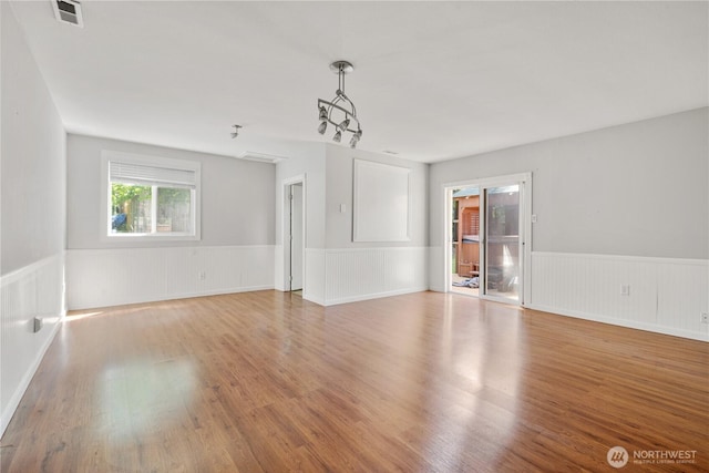 17004 11th Ave NE, Shoreline, WA 98155 - unfurnished living room with light wood-style flooring and a wainscoted wall