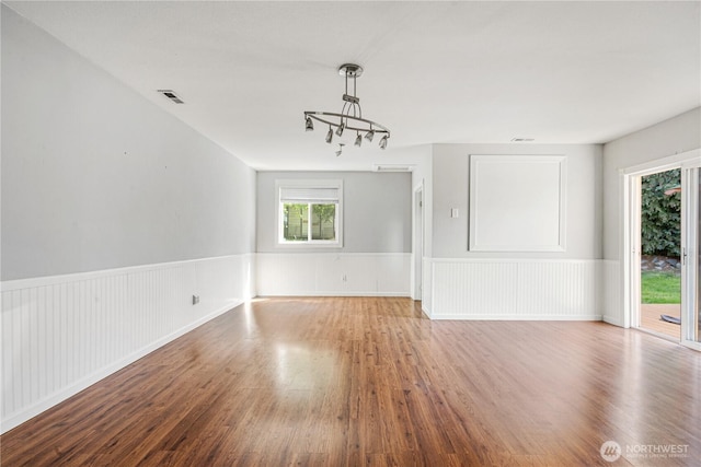 17004 11th Ave NE, Shoreline, WA 98155 - spare room featuring a chandelier, wood finished floors, and a wainscoted wall