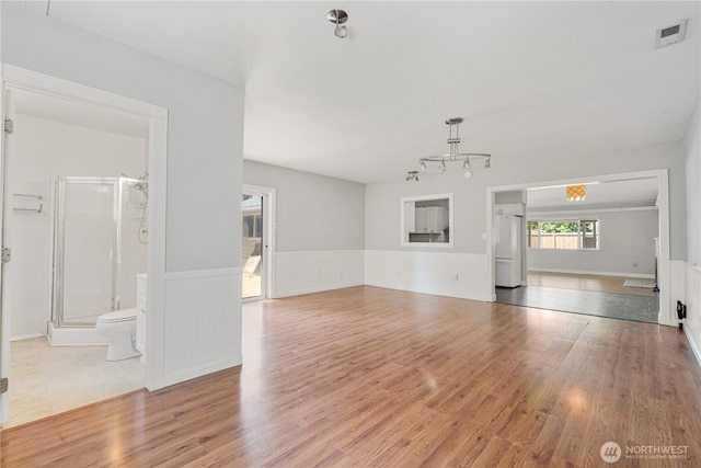 17004 11th Ave NE, Shoreline, WA 98155 - unfurnished living room featuring wood finished floors, a wainscoted wall, and a chandelier
