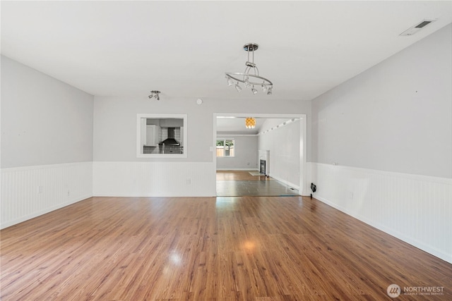 17004 11th Ave NE, Shoreline, WA 98155 - unfurnished living room with wainscoting, a chandelier, and wood finished floors