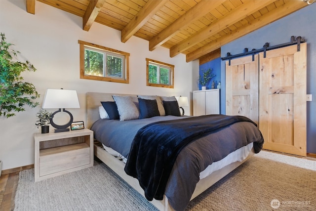 6570 E Grapeview Loop Rd, Allyn, WA 98524 - bedroom featuring wood ceiling with exposed beams, a barn door, wood finished floors, and baseboards