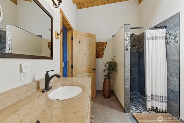 6570 E Grapeview Loop Rd, Allyn, WA 98524 - full bath featuring tiled shower, tile patterned flooring, vanity, and lofted ceiling