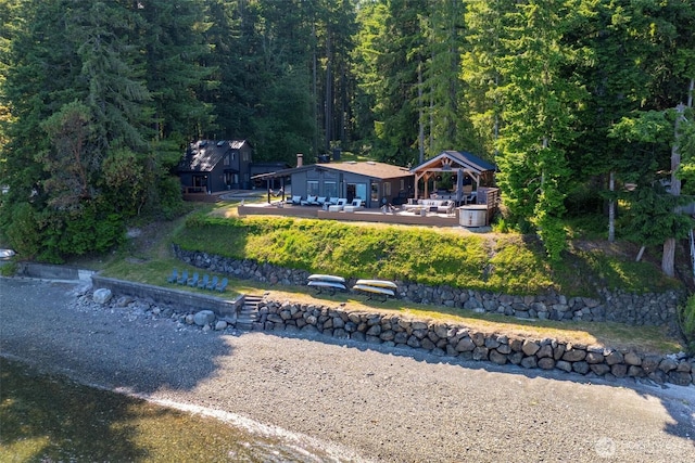 6570 E Grapeview Loop Rd, Allyn, WA 98524 - rear view of house with a gazebo, a wooded view, an outbuilding, and a deck