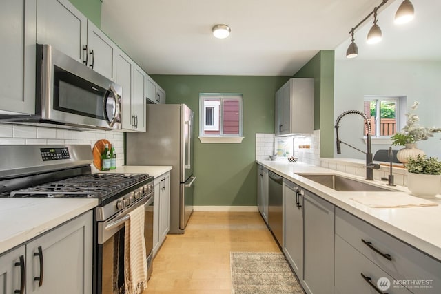 4121 Martin Luther King Jr Way S, Seattle, WA 98108 - kitchen with stainless steel appliances, tasteful backsplash, gray cabinetry, and light wood finished floors