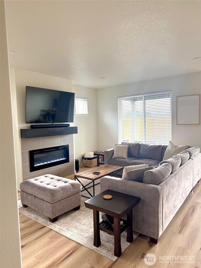 603 Cardinal Ave, Winlock, WA 98596 - living area with wood finished floors, a glass covered fireplace, and a textured ceiling