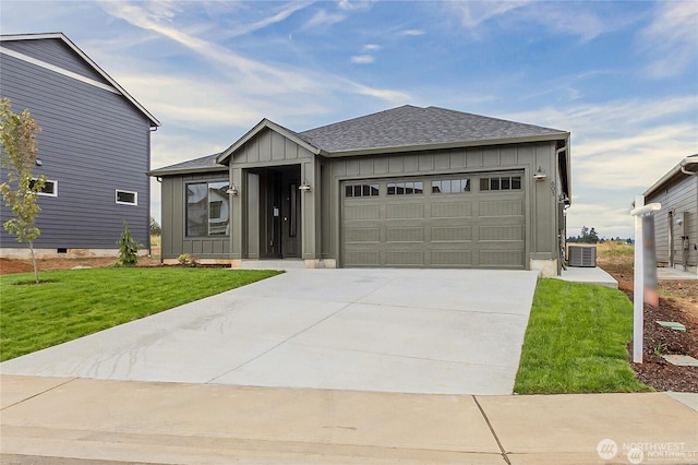 603 Cardinal Ave, Winlock, WA 98596 - view of front facade with board and batten siding, a garage, central air condition unit, concrete driveway, and a front lawn