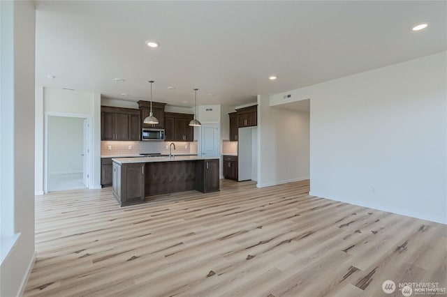 603 Cardinal Ave, Winlock, WA 98596 - kitchen featuring stainless steel appliances, a sink, light countertops, light wood-type flooring, and backsplash