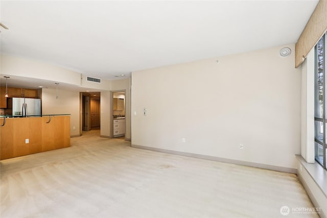 2929 1st Ave Unit 205, Seattle, WA 98121 - unfurnished living room featuring baseboards and light colored carpet