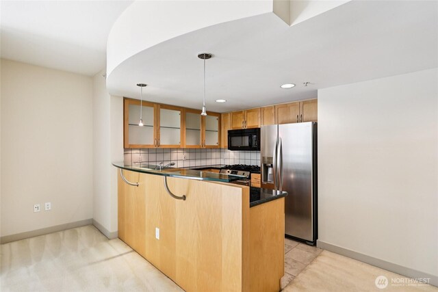 2929 1st Ave Unit 205, Seattle, WA 98121 - kitchen featuring stainless steel appliances, a peninsula, dark countertops, glass insert cabinets, and decorative backsplash