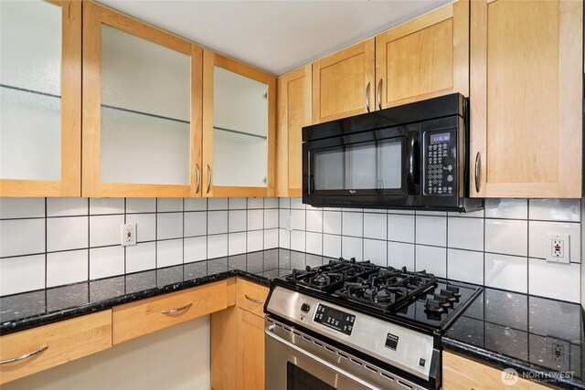 2929 1st Ave Unit 205, Seattle, WA 98121 - kitchen featuring black microwave, stainless steel gas range, tasteful backsplash, dark stone counters, and glass insert cabinets