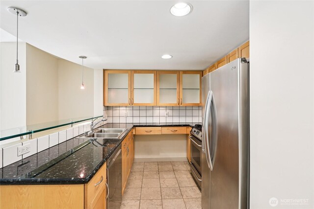 2929 1st Ave Unit 205, Seattle, WA 98121 - kitchen featuring appliances with stainless steel finishes, glass insert cabinets, pendant lighting, decorative backsplash, and dark stone countertops