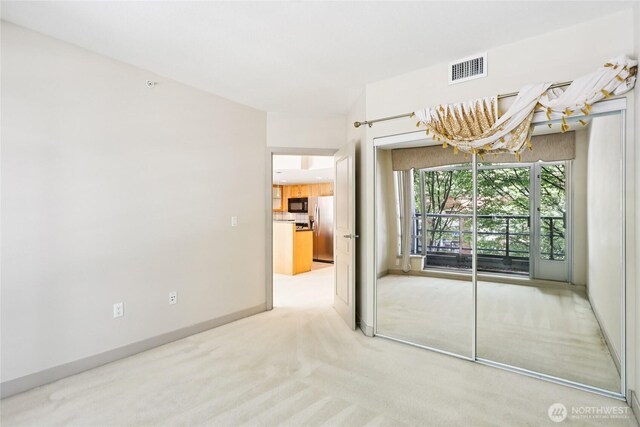 2929 1st Ave Unit 205, Seattle, WA 98121 - unfurnished room featuring light colored carpet and baseboards