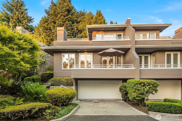 740 1st St S, Kirkland, WA 98033 - back of property with stucco siding, a garage, and a balcony