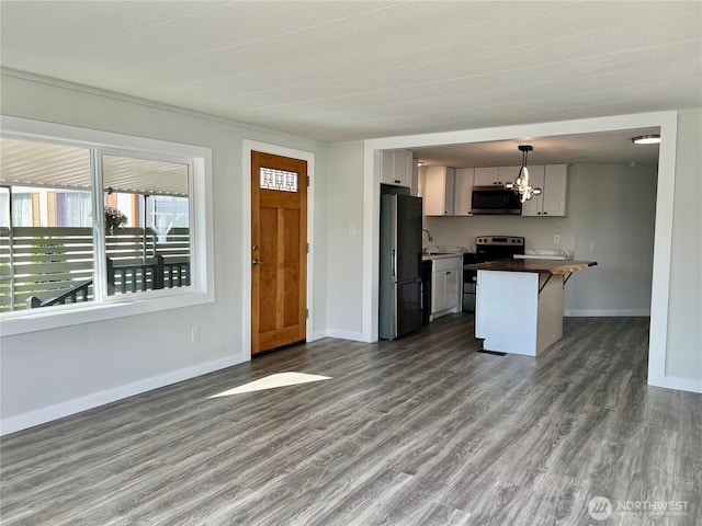 18501 52nd Ave W Unit 84, Lynnwood, WA 98037 - kitchen featuring appliances with stainless steel finishes, a chandelier, a sink, dark wood-style floors, and a kitchen bar