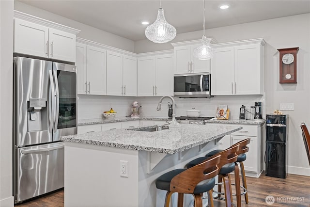 1924 Schneiter Dr, Longview, WA 98632 - kitchen featuring appliances with stainless steel finishes, a sink, white cabinetry, tasteful backsplash, and dark wood finished floors
