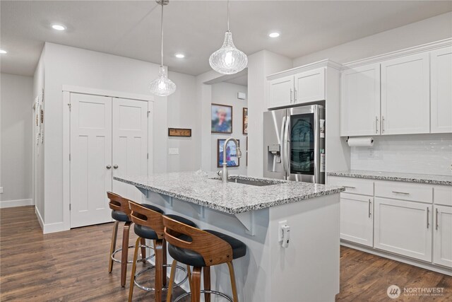 1924 Schneiter Dr, Longview, WA 98632 - kitchen featuring stainless steel fridge with ice dispenser, a sink, white cabinets, dark wood finished floors, and light stone countertops