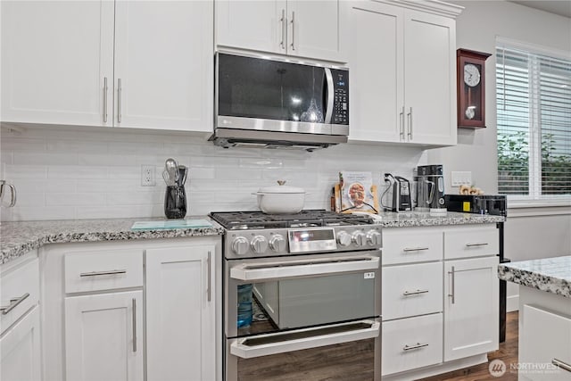 1924 Schneiter Dr, Longview, WA 98632 - kitchen with stainless steel appliances, tasteful backsplash, white cabinetry, dark wood-style floors, and light stone counters