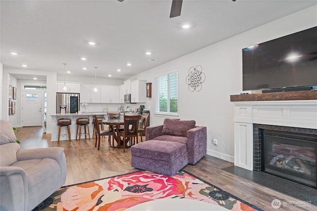 1924 Schneiter Dr, Longview, WA 98632 - living area with wood finished floors, a ceiling fan, recessed lighting, a glass covered fireplace, and baseboards