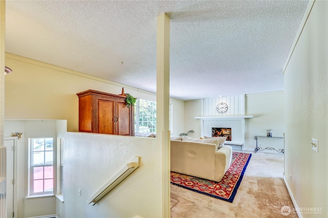 26421 Kingsview Loop NE, Kingston, WA 98346 - living area with a textured ceiling, a fireplace, and light colored carpet
